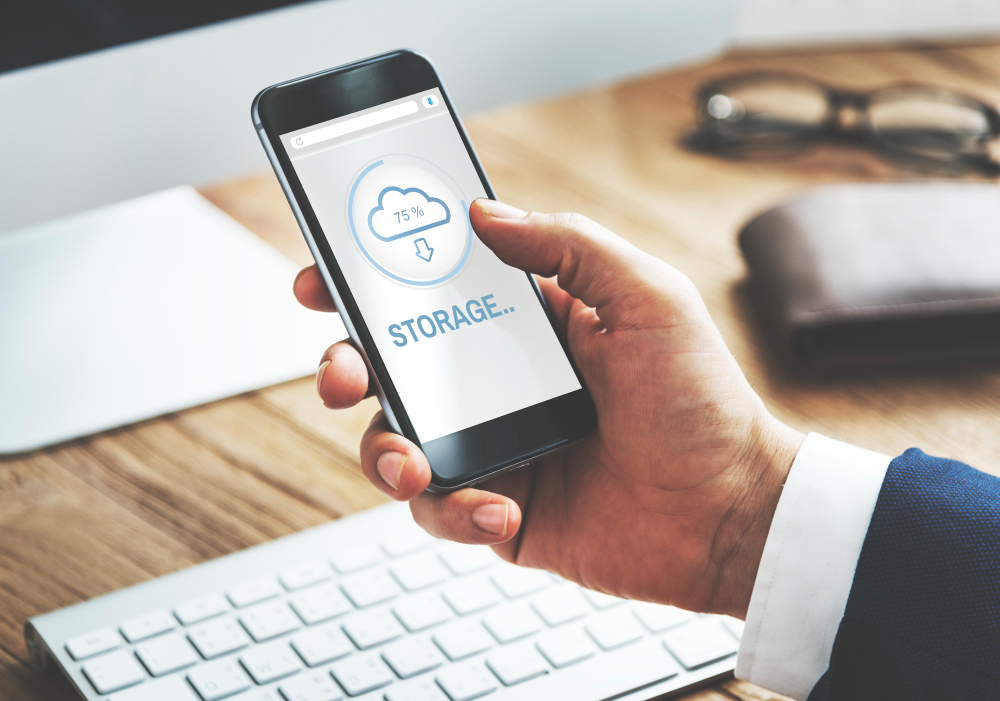 A Man holding a phone with a screen shows cloud-storage