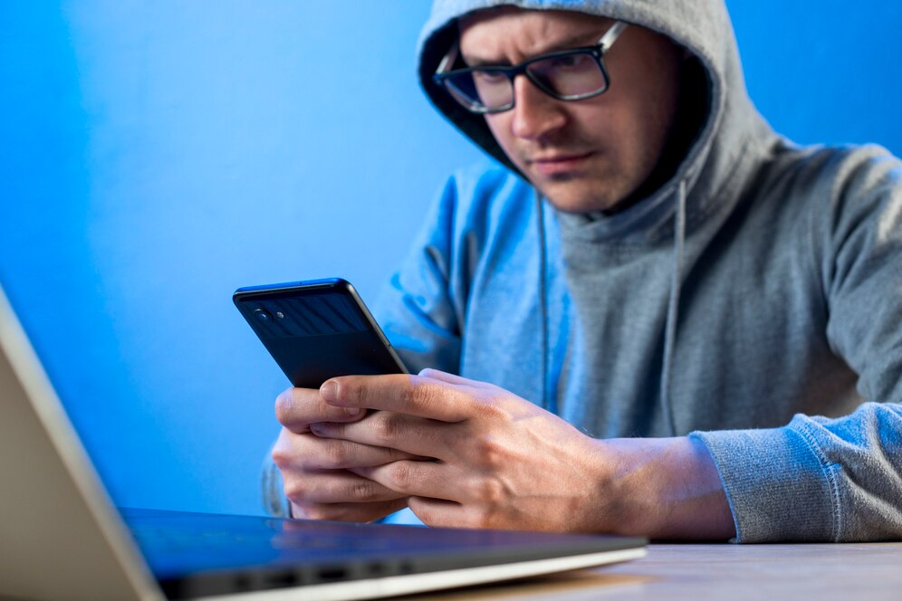 A man staring at his phone due to a scam message