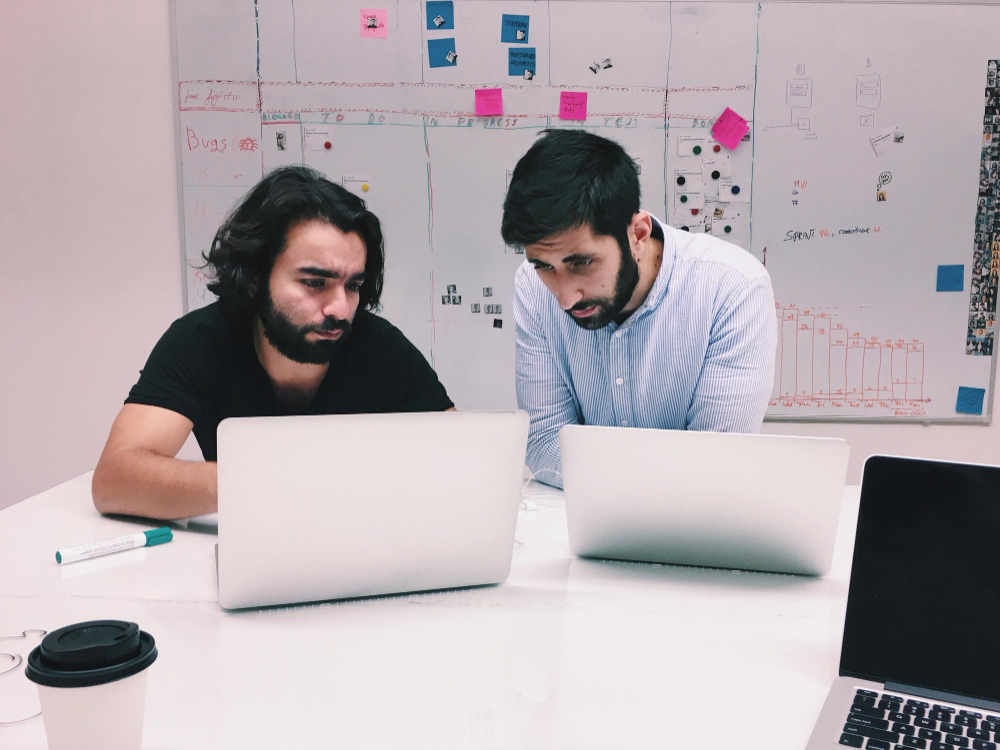 Two IT team members working on a laptop